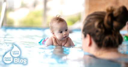 Mama hält ihr Baby im Wasser während des Babyschwimmkurses