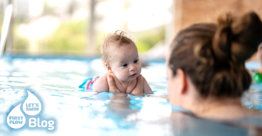 Mama hält ihr Baby im Wasser während des Babyschwimmkurses
