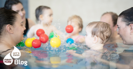 Kinder mit Eltern im Kreis im Wasser beim Babyschwimmkurs MAXIS, spielen mit Bällen und lernen spielerisch Schwimmbewegungen.