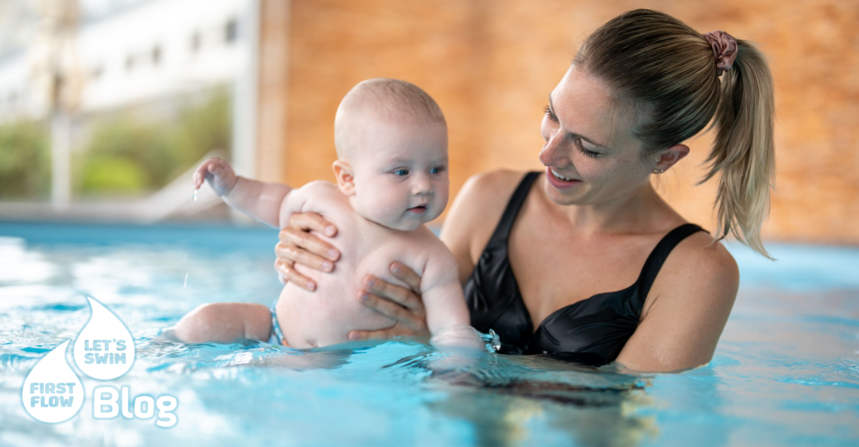Mutter hält ihre kleine Tochter im Wasser beim Babyschwimmkurs