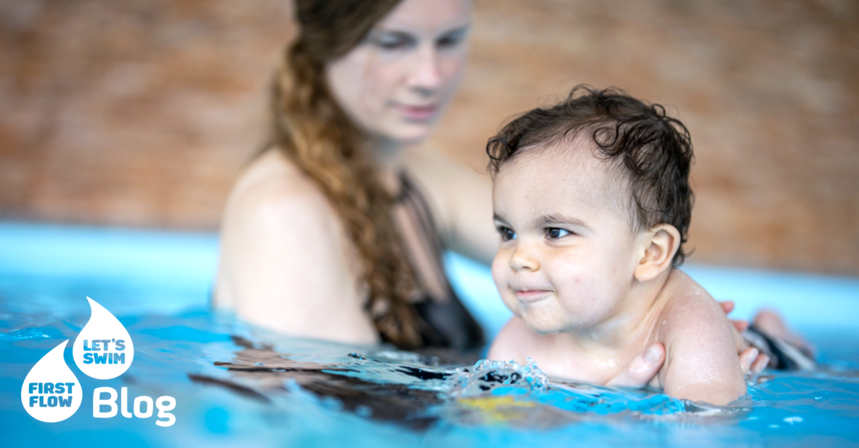 Mama hält ihren kleinen Sohn im Wasser beim Babyschwimmkurs – Tipps für sicheren Sonnenschutz für Babys und Kinder.